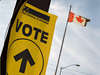 An Elections Canada "vote" sign is seen next to a Canadian flag.