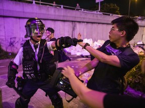 A riot police gestures towards Joshua Wong, co-founder of the Demosito political party, during a protest in the Shatin district of Hong Kong, China, on Sunday, July 14, 2019. University of Calgary students on exchange programs in the Chinese-controlled city are likely returning home early due to violence.