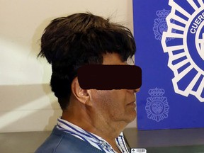 A man poses with a toupee with a drug package under it after being arrested in Barcelona, Spain, in this picture released on July 16, 2019.