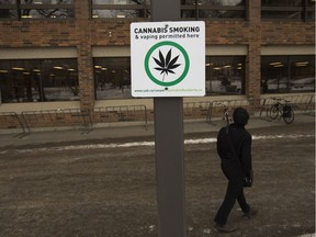 A pedestrian talks past a marked cannabis smoking zone west of the Rutherford Library at the University of Alberta.