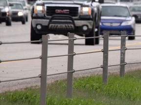 Traffic whizzes by the cable barrier between lanes on Deerfoot Trail.