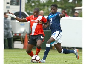 Cavalry FC Elijah Adekugbe (L) competes in midfield against  Edmonton FC Edem Mortotski during CPL soccer action between Cavalry FC and FC Edmonton at ATCO Field at Spruce Meadows in Calgary on Friday, August 16, 2019. Jim Wells/Postmedia