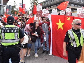 Vancouver police officers keep pro-China supporters away from pro-Hong Kong supporters during a demonstration for both pro and against extradition law changes in Hong Kong rallied at the Broadway-City Hall SkyTrain Station in Vancouver, Canada on August 17, 2019.