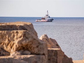 (FILES) In this file photo taken on August 17, 2019 the Spanish migrant rescue NGO ship Open Arms is seen off the coast of the Italian island of Lampedusa. - Ten migrants rescued by the charity ship Open Arms leapt into the water on August 20, 2019, to try and swim to the nearby Italian island of Lampedusa in desperation after days stuck on board. The Open Arms ship has been stuck off Lampedusa for days seeking permission to dock, with the situation increasingly tense as migrants, many of whom have been on board for 19 days since their rescue off Libya, grow desperate. Ten of the 98 migrants on board threw themselves in the water to try and swim to Lampedusa, just a stone's throw away.