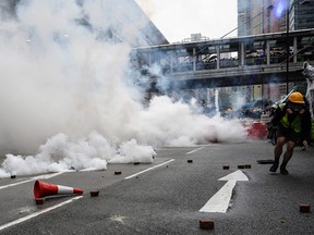 Protesters return tear gas towards the police in Tseun Wan in Hong Kong on August 25, 2019 in the latest opposition to a planned extradition law that has since morphed into a wider call for democratic rights in the semi-autonomous city. - Hong Kong police used water cannon for the first time and at least one officer fired his sidearm during pitched battles with protesters on August 25, one of the most violent nights in three months of pro-democracy rallies that have rocked the city. An afternoon rally in the district of Tsuen Wan spiralled into violent running confrontations between protesters and police, with officers several times caught outnumbered and isolated by masked youths wielding sticks and throwing rocks. (Photo by Philip FONG / AFP)PHILIP FONG/AFP/Getty Images