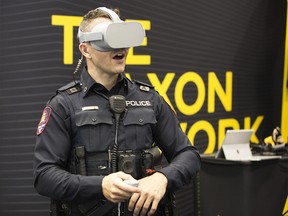 Calgary Police Service Cst. Adam Osmond tries out some of the technology in the Axon booth at the Canadian Association of Chiefs of Police Conference trade show at the Telus Convention Centre in Calgary, Monday August 12, 2019.  Gavin Young/Postmedia