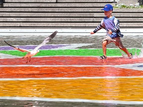 Cameron Ens, 5, plays in the water in Olympic Plaza in Calgary on Tuesday August 13, 2019. The pool appeared to have re-opened after being closed for health reasons. Gavin Young/Postmedia