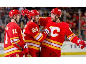 Calgary Flames Travis Hamonic celebrates with teammates Mikael Backlund and Noah Hanifin after scoring against the New York Islanders in NHL hockey at the Scotiabank Saddledome in Calgary on Wednesday, February 20, 2019. Al Charest/Postmedia