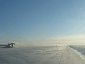 Snow ploughs keep the metre-plus thick ice road on Yellowknife Bay clear for traffic.