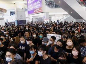 Anti-government protesters block the access to the departure gates, during a demonstration at Hong Kong Airport, China August 13, 2019.
