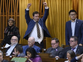 Liberal MPs Salma Zahid, left to right, Nick Whalen and Geng Tan rise for the final vote at the end of a 30-hour marathon voting session that began on Wednesday and lasted until 1 a.m. on Friday, March 22, 2019, in in the House of Commons on Parliament Hill in Ottawa.