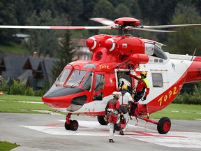 Mountain rescue team (TOPR) members board a helicopter in Zakopane, Poland August 18, 2019, to join the search operation for two cave climbers trapped in the Tatra mountains.  Agencja Gazeta/Marek Podmokly via REUTERS ATTENTION EDITORS - THIS IMAGE WAS PROVIDED BY A THIRD PARTY. POLAND OUT NO COMMERCIAL OR EDITORIAL SALES IN POLAND ORG XMIT: ZAK300