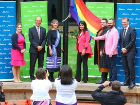 Leela Sharon Aheer, Minister of Culture, Multiculturalism and Status of Women, raises the Pride flag in Calgary with Minister Rebecca Schulz, Associate Minister Jason Luan, Sandra Sutter (Aboriginal Friendship Centre of Calgary), Spencer Belanger (Calgary Outlink Centre for Gender and Sexual Diversity), Dustin Franks (Calgary City Hall), and MLA Mike Ellis, outside the McDougall Centre in Calgary on Monday, August 26, 2019.