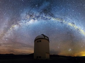 The warped shape of the stellar disk of the Milky Way galaxy, determined by mapping the distribution of young stars called Cepheids with distances set out in light years, is seen over the Warsaw University Telescope at Las Campanas Observatory in Chile, in an artist's rendition released August 1, 2019. Jan Skowron/University of Warsaw/Handout via REUTERS.