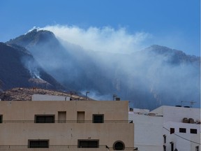 Smoke from a forest fire is seen in the village of Agaete, in the Canary Island of Gran Canaria, Spain, August 21, 2019. REUTERS/Borja Suarez ORG XMIT: BOR_001