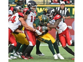 Edmonton Eskimos Jordan Robinson (22) gets taken down by Calgary Stampeders Ante Milanovic-Litre (34), Royce Metchie (16) and Troy Stoudermire (R) during CFL action at Commonwealth Stadium in Edmonton, September 8, 2018. Ed Kaiser/Postmedia