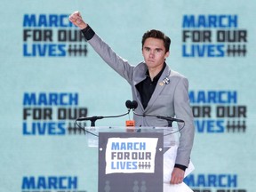FILE PHOTO: David Hogg, a student at the Marjory Stoneman Douglas High School, site of a February mass shooting which left 17 people dead in Parkland, Florida, thrusts his fist in the air as he speaks during the "March for Our Lives" event demanding gun control after recent school shootings at a rally in Washington, U.S., March 24, 2018. REUTERS/Aaron P. Bernstein/File Photo ORG XMIT: FW1