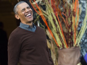 US President Barack Obama laughs as he arrives to hand out treats to children trick-or-treating for Halloween on the South Lawn of the White House in Washington, DC, October 30, 2015.