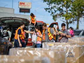 Volunteers help unload the donations into the Calgary Food Bank boxes during the City-Wide Food Drive at Westbrook Mall in Calgary on Saturday, September 14, 2019. Azin Ghaffari/Postmedia Calgary