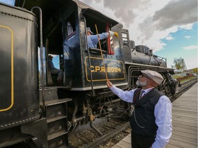 Glenn Oullette hands off a message on a hoop to the passing locomotive to demonstrate the old method of transferring information at Train Days eat Heritage Park in Calgary, Ab., on Saturday September 24, 2016. Mike Drew/Postmedia