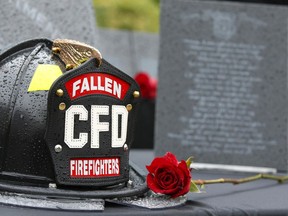 A rose rests in front of a ceremonial helmet during a noon hour ceremony at City Hall honouring fallen Calgary Firefighters Tuesday, September 10, 2019.