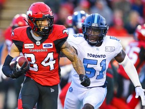 Calgary Stampeders Reggie Begelton takes off with the ball under pressure from Micah Awe of the Toronto Argonauts during CFL football in Calgary on Thursday, July 18, 2019. Al Charest/Postmedia