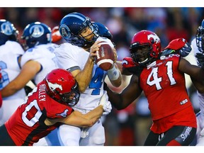 Toronto Argonauts quarterback McLeod Bethel-Thompson is sacked by Nate Holley and Cordarro Law of the Calgary Stampeders  during CFL football in Calgary on Thursday, July 18, 2019. Al Charest/Postmedia