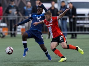 FC Edmonton's Allan Zebie (4) battles the Cavalry FC's Nico Pasquotti (17) during Canadian Premier League action at Clarke Field, in Edmonton Wednesday Sept. 11, 2019. Photo by David Bloom