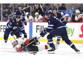 Sep 22, 2019; Winnipeg, Manitoba, CAN;  Calgary Flames right wing Alexandre Grenier (44) is taken down by Winnipeg Jets defenseman Dmitry Kulikov (7) in the first period at Bell MTS Place. Mandatory Credit: James Carey Lauder-USA TODAY Sports ORG XMIT: USATSI-406660