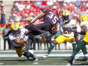 Calgary Stampeders Ka'Deem Carey is tackled by Edmonton Eskimos Don Unamba in the first half of the Labour Day Classic at McMahon Stadium on Monday, Sept. 2, 2019.