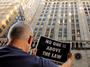 Demonstrators hold protest signs as part of a demonstration in support of impeachment hearings in New York, U.S., September 26, 2019.