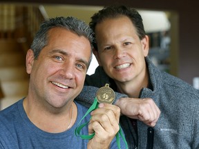 Kidney donor Tony Timmons, left, with recipient Ryan McLennan hold up their medals and pins in Calgary on Sunday, Oct. 27, 2019.