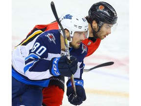 Calgary Flames Dillon Dube battles against Michael Spacek of the Winnipeg Jets  during pre-season NHL hockey in Calgary on Tuesday September 24, 2019. Al Charest / Postmedia