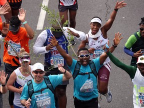 Activist and treegrower Siyabulela Sokomani celebrates as he approaches the final stretch of the Cape Town marathon, in South Africa September 15, 2019. He is one of a group of 20 runners participating in the marathon with saplings on their backs to promote the planting of native trees amid a nationwide push to replace invasive species with indigenous ones to cope with drought and climate change. REUTERS/Mike Hutchings ORG XMIT: HFSGGGMSH03