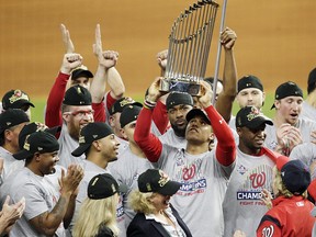 Juan Soto #22 of the Washington Nationals hoists the Commissioners Trophy after defeating the Houston Astros 6-2 in Game Seven to win the 2019 World Series in Game Seven of the 2019 World Series at Minute Maid Park on October 30, 2019 in Houston, Texas. (Photo by Bob Levey/Getty Images)