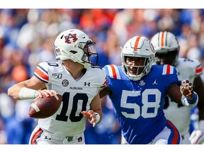 GAINESVILLE, FLORIDA - OCTOBER 05: Bo Nix #10 of the Auburn Tigers is pressured by Jonathan Greenard #58 of the Florida Gators during the first quarter of a game at Ben Hill Griffin Stadium on October 05, 2019 in Gainesville, Florida.