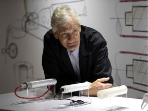 In this file photo taken on Oct. 11, 2018, British industrial design engineer and founder of the Dyson company, James Dyson, poses with products during a photo session at a hotel in Paris. Dyson, famed for his vacuum cleaners, announced Thursday, October 10, that he has abandoned his bid to mass produce electric cars because it was not "commercially viable". (Photo by Christophe ARCHAMBAULT / AFP)