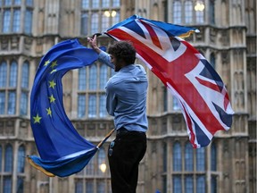 (FILES) In this file photo taken on June 28, 2016 A man waves both a Union flag and a European flag together on College Green outside The Houses of Parliament at an anti-Brexit protest in central London on June 28, 2016. - Whether Prime Minister Boris Johnson succeeds in having his Brexit agreement adopted quickly or not in the British Parliament, uncertainty for business is far from being dispelled. (Photo by JUSTIN TALLIS / AFP) (Photo by JUSTIN TALLIS/AFP via Getty Images)