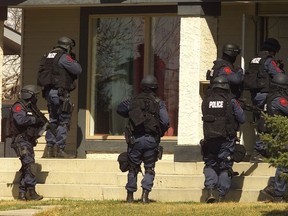Calgary police's tactical unit members enter a home in this undated file photo.