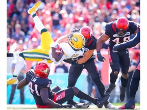 Edmonton Eskimos Natey Adjei is tackled by Cordarro Law and Cory Greenwood Calgary Stampeders during CFL football in Calgary on Monday, September 2, 2019. Al Charest/Postmedia