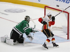 CP-Web.  Calgary Flames left wing Johnny Gaudreau (13) gets the puck past Dallas Stars goaltender Ben Bishop (30) to score during the shootout in an NHL hockey game in Dallas, Thursday, Oct. 10, 2019. Calgary won 3-2.