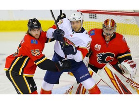 Calgary Flames Noah Hanifin battles against Colton Sceviour of the Florida Panthers during NHL hockey in Calgary on Thursday October 24, 2019. Al Charest / Postmedia