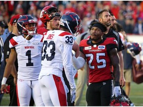 The Calgary Stampeders' Don Jackson talks with the Montreal Alouettes Jarnor Jones as they await a review after Eric Rogers' touchdown pass. The pass was eventually ruled caught out of bounds ending the Stampeders chance in overtime against the Montreal Alouettes during CFL action in Calgary on Saturday Aug. 17. File photo by Gavin Young/Postmedia.