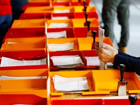 A member of the district election office Stadtkreis 3 sorts ballots for the Swiss federal elections in Zurich, Switzerland October 20, 2019. REUTERS/Arnd Wiegmann ORG XMIT: AW411