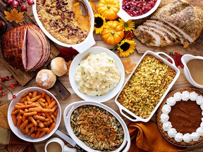 Thanksgiving table with roasted turkey, sliced ham and side dishes