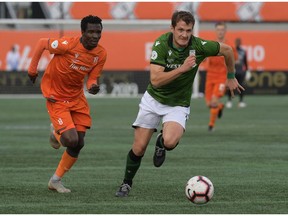 Oct 26, 2019; Hamilton, Ontario, CAN;  Cavalry FC defender  Mason Trafford (5, right) chases the ball ahead of Forge FC defender Elimane Cisse (3) in the first half of a Canadian Premier League soccer final match at Tim Hortons Field. Mandatory Credit: Dan Hamilton-USA TODAY Sports for CPL ORG XMIT: USATSI-415705