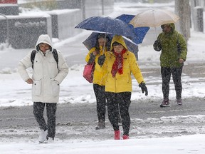 Pedestrians navigate ice and snow in Calgary on Sunday, Sept. 29, 2019.
