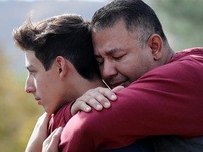 Marco Reynoso (R) hugs his son, 11th-grader Dylan Reynoso, after reuniting at a park near Saugus High School after a shooting at the school left two students dead and three wounded on November 14, 2019 in Santa Clarita, California.