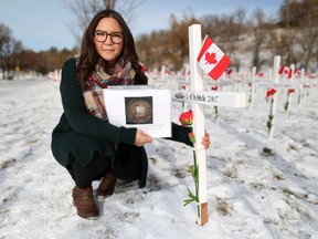 Stephanie Watts holds a photo of the plaque of condolence for her great- great-grandfather Samual Watts next to his cross in the Field of Crosses on Thursday November 7, 2019. The plaque was the only thing that survived a fire in 1968 and she hopes that a collector in Southern Alberta may have the so-called 'death penny' that was given to relatives after fallen soldiers after the First World War. Samual Watts was a well known Southern Alberta musician and one of the first black Canadian soldiers to die in the war.