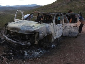 Members of the Lebaron family watch the burned car where part of the nine murdered members of the family were killed and burned during an gunmen ambush on Bavispe, Sonora mountains, Mexico, on November 5, 2019.